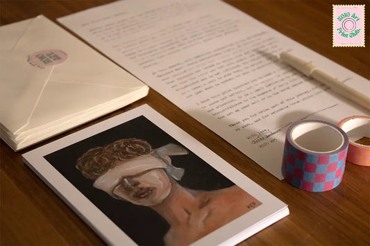 Art print “Blinded Man” van KOJO Art, samen met een brief, enveloppen en masking tape op een houten tafel. Onderdeel van de oktobereditie van de Print Club. – een maandelijkse kunstabonnement en snailmail-art experience.