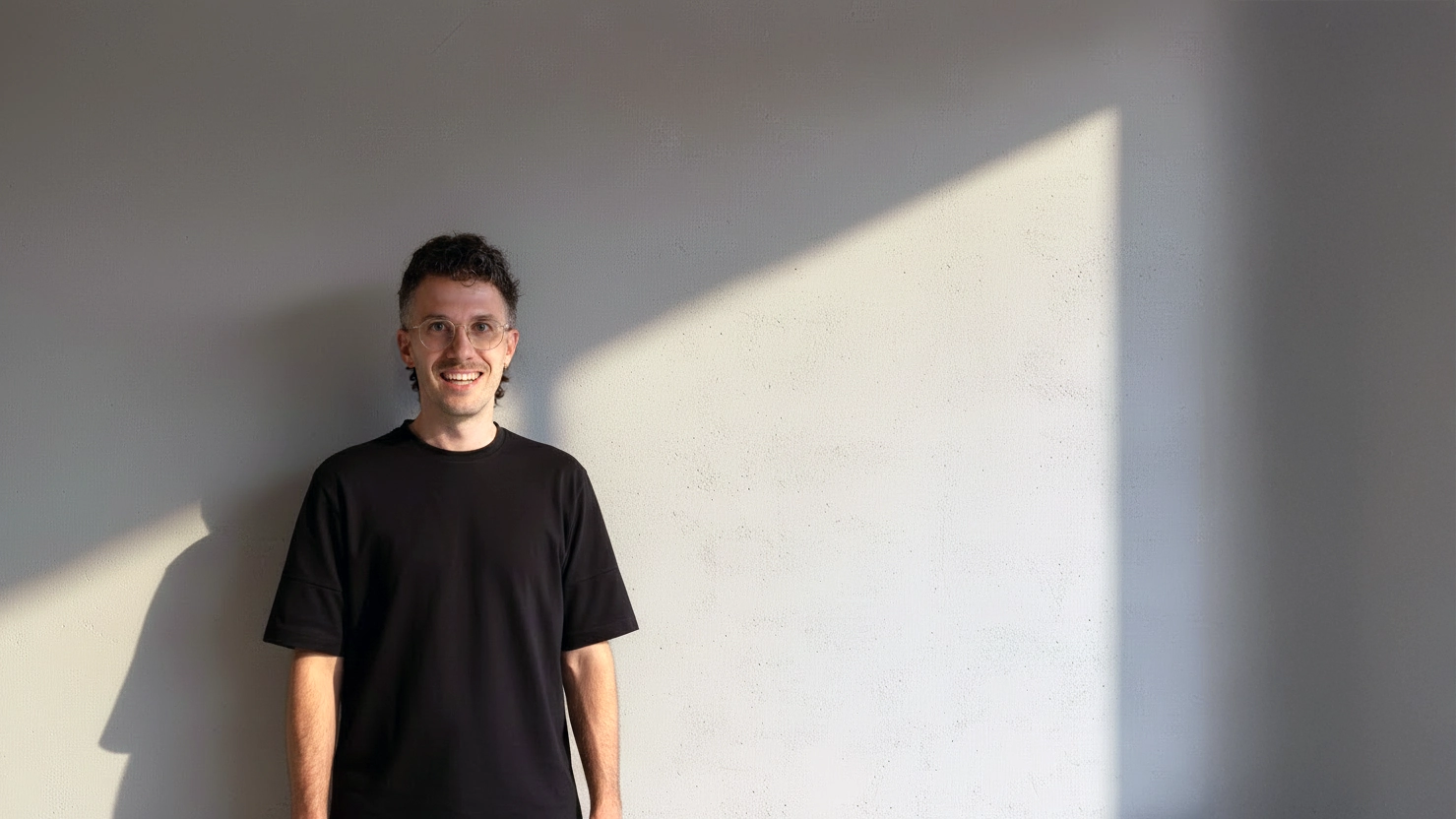 Jordy Koumans, kunstenaar en oprichter van KOJO Art, in minimalistische betonnen studio met natuurlijk licht.